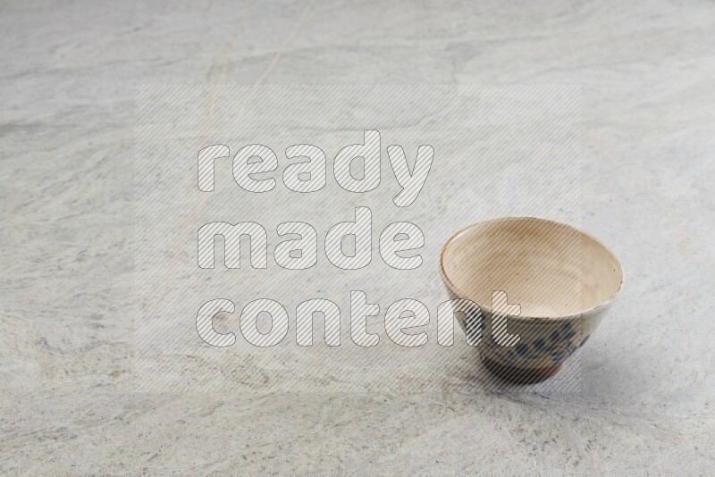 A multicolored pottery bowl on grey marble background