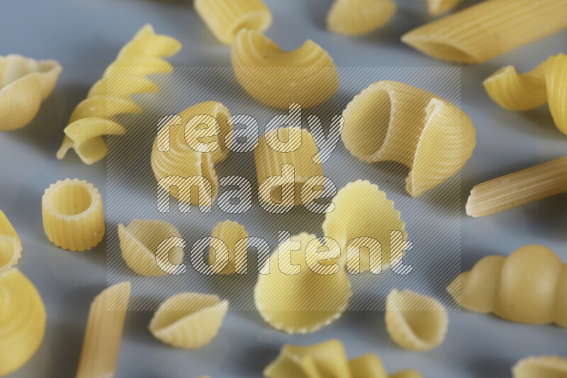 Different pasta types on light blue background