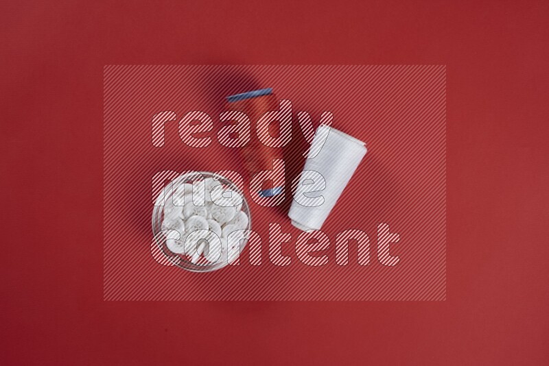 A white collection of sewing and tailoring tools arranged on a red background