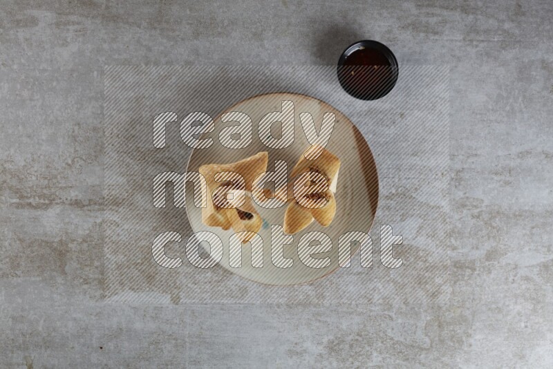 wonton cups with soy sauce ramkin on multi colored pottery on grey textured counter top