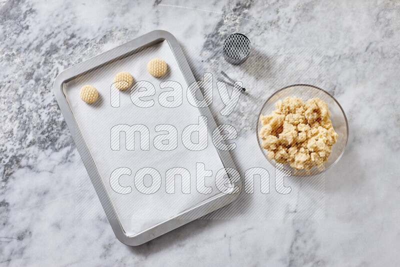 Kahk step by step with its ingredients ghee, sugar, flour, sesame, yeast, water and kahk flavor on grey marble background