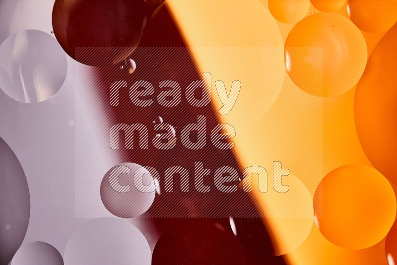 لقطات مقربة لفقاعات من الزيت على سطح الماء باللون الأبيض والبرتقالي