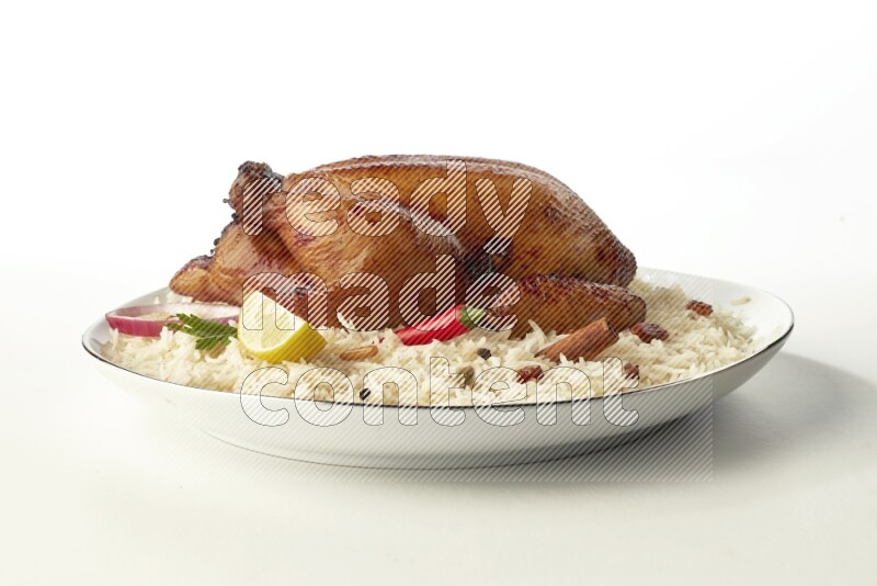 white  basmati Rice with  whole roasted chicken  on a white plate with a silver rim direct  on white background