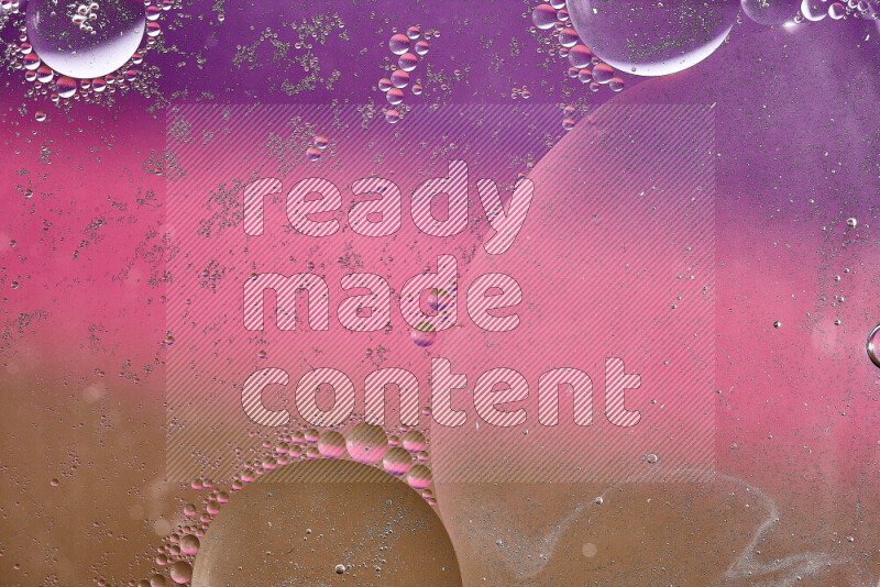 لقطات مقربة لفقاعات من الزيت على سطح الماء باللون البني والأرجواني والوردي