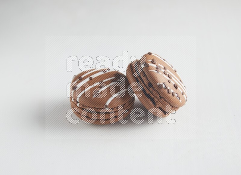 45º Shot of two Brown white Chocolate Caramel macarons on white background