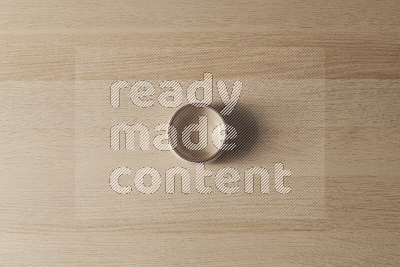 A beige pottery oven bowl on light wooden background