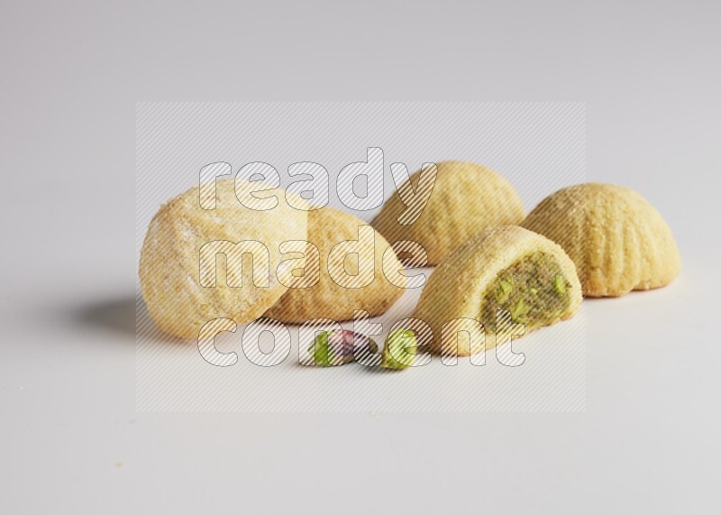 Five Pieces of Maamoul filled with pistachio  paste one of them is cut direct on white background