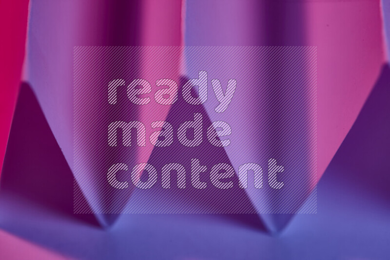 A close-up abstract image showing sharp geometric paper folds in purple gradients