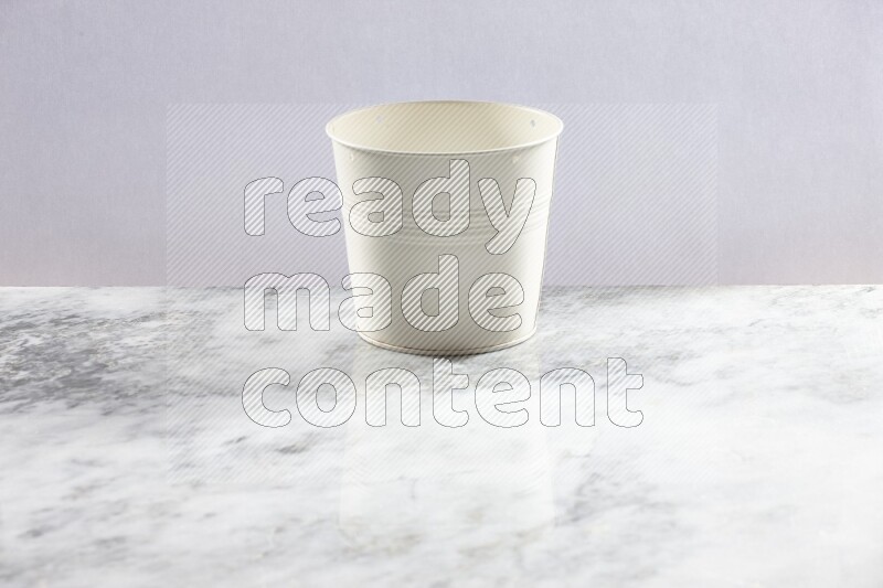 An empty white plant pot on grey marble background