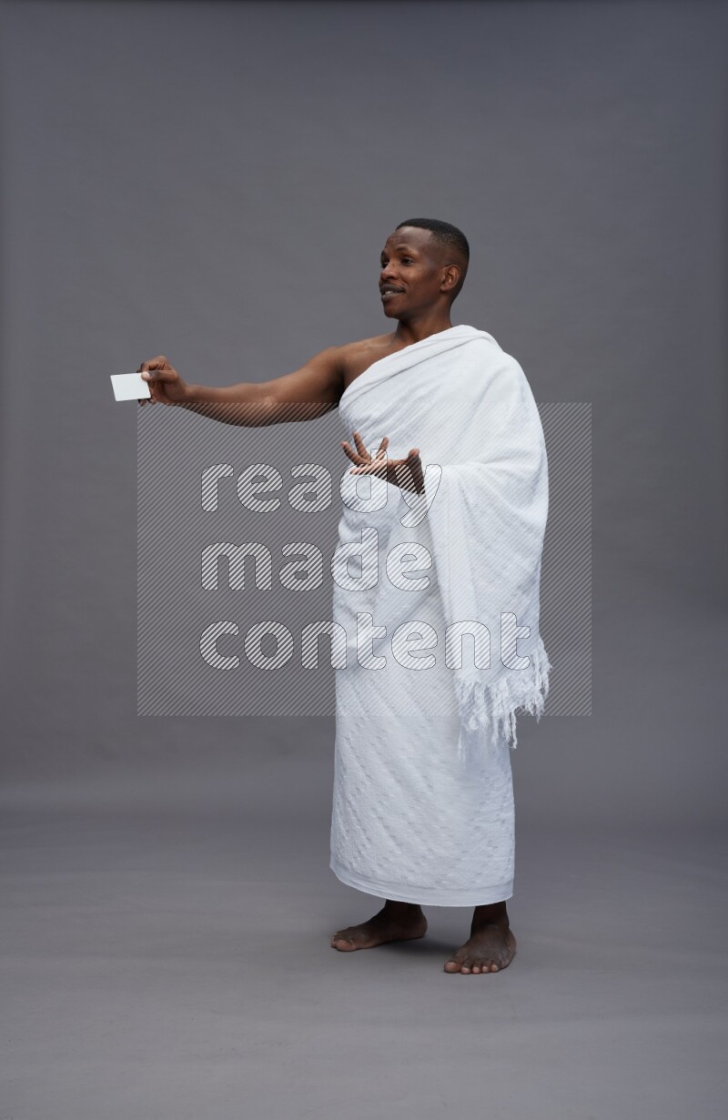 A man wearing Ehram Standing holding ATM card on gray background