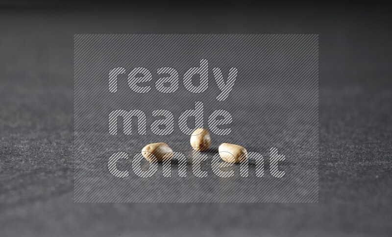 3 peeled peanuts on a black background in different angles