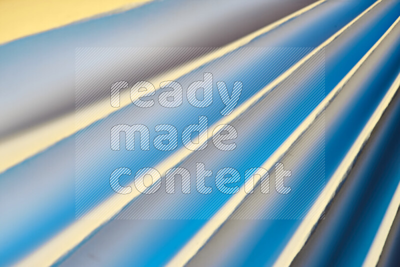 An image presenting an abstract paper pattern of lines in blue and gold tones