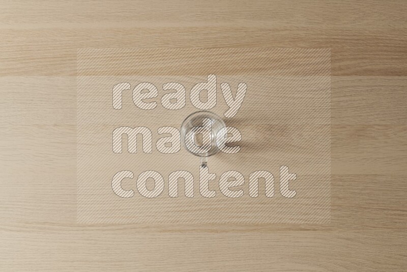 An empty glass cup on light wooden background