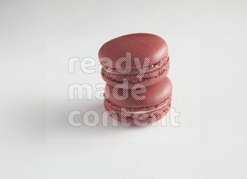 45º Shot of two Red Velvet macarons on white background