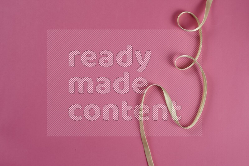 A green and pink collection of sewing and tailoring tools arranged on a pink background