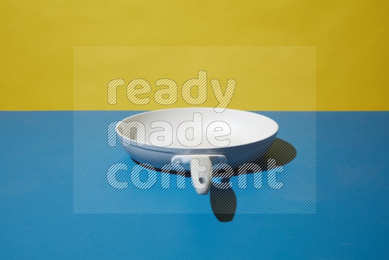 white pan on yellow and Blue background