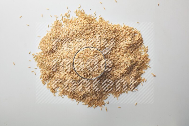 Top-view shot of long grain brown rice in a container on white background