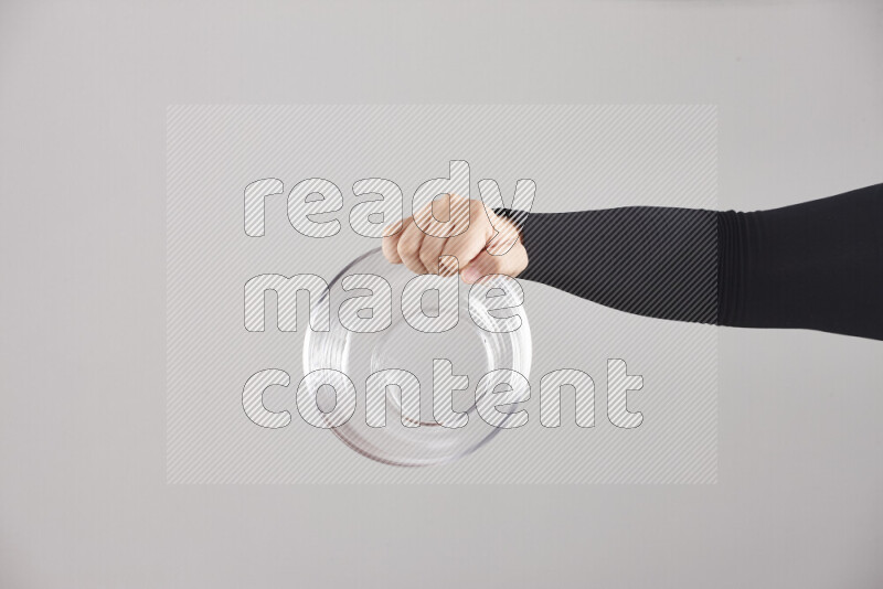 امرأة ترتدي عباءة سوداء تحمل أدوات زجاجية مختلفة في أوضاع متعددة