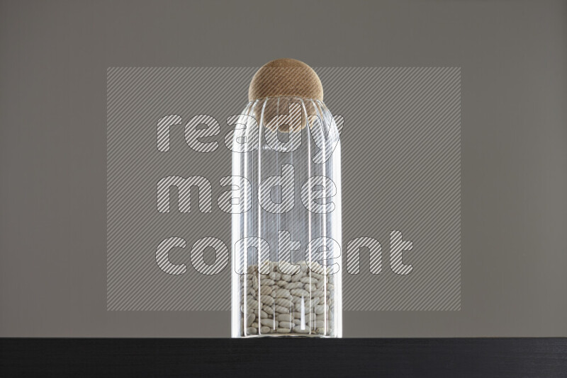 White beans in a glass jar on black background
