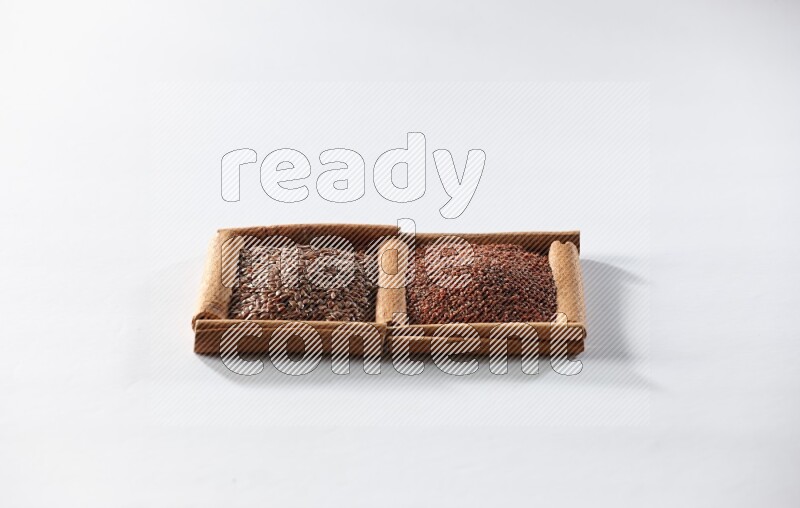 2 squares of cinnamon sticks full of flaxseeds and garden cress on white flooring