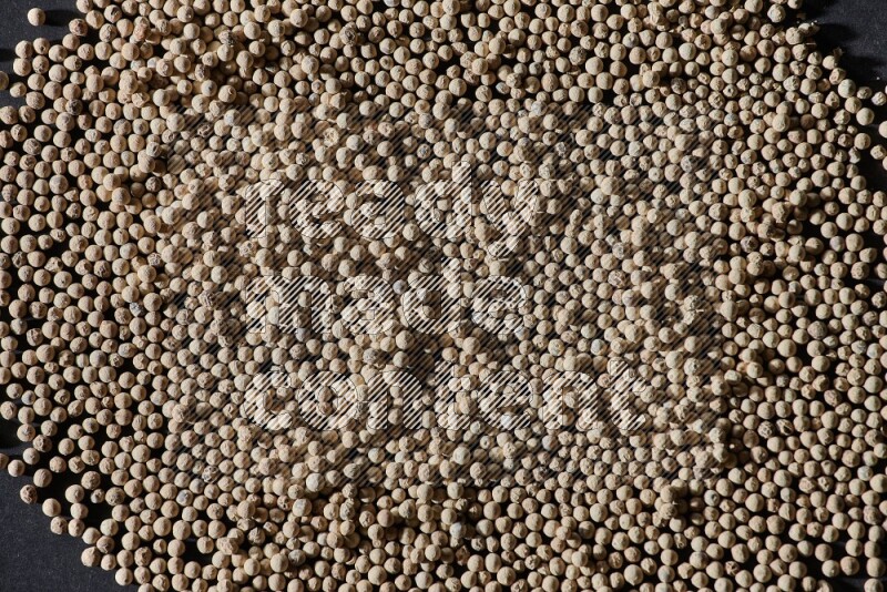 White pepper beads on black flooring