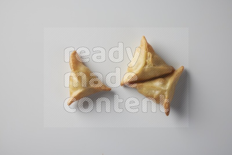 Three fried sambosa from a top angle on a white background