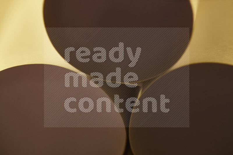 الصورة تعرض فن ورقي تجريدي بأشكال دائرية بدرجات متنوعة من اللون الذهبي