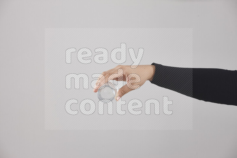 A woman in black abaya holding different glassware in different positions