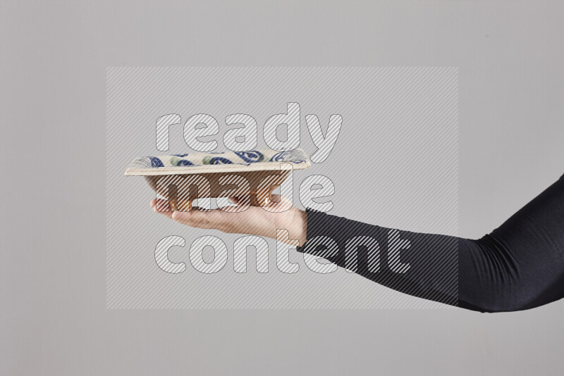 A woman in black abaya holding different pottery essentials in different positions