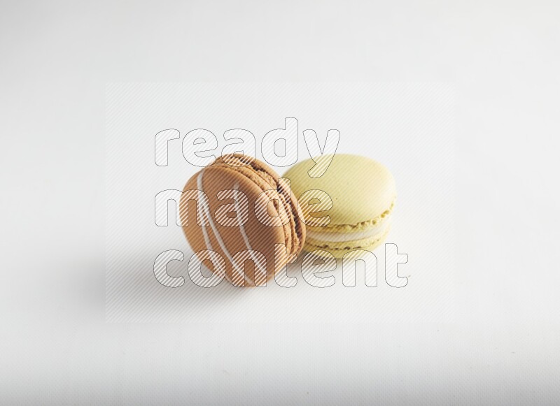 45º Shot of of two assorted Brown Irish Cream, and Yellow Lime macarons on white background