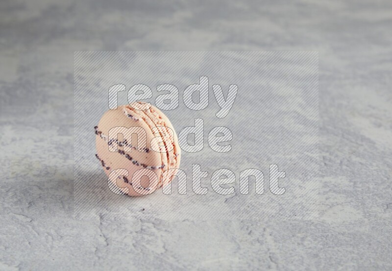 45º Shot of pink orange blossom macaron on white  marble background