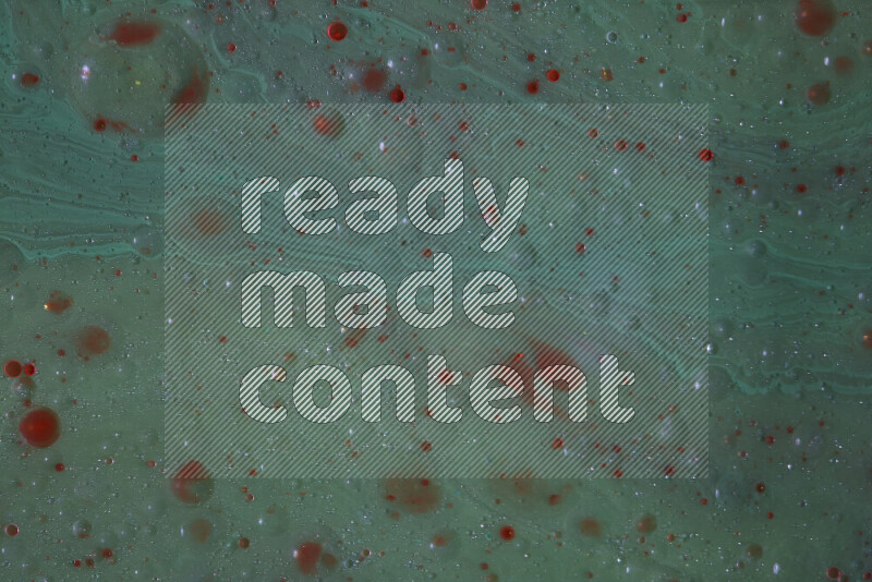 The image captures a dramatic splatter of red paint over a green backdrop