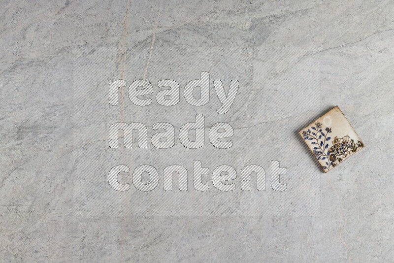 A decorative pottery coaster on grey marble background