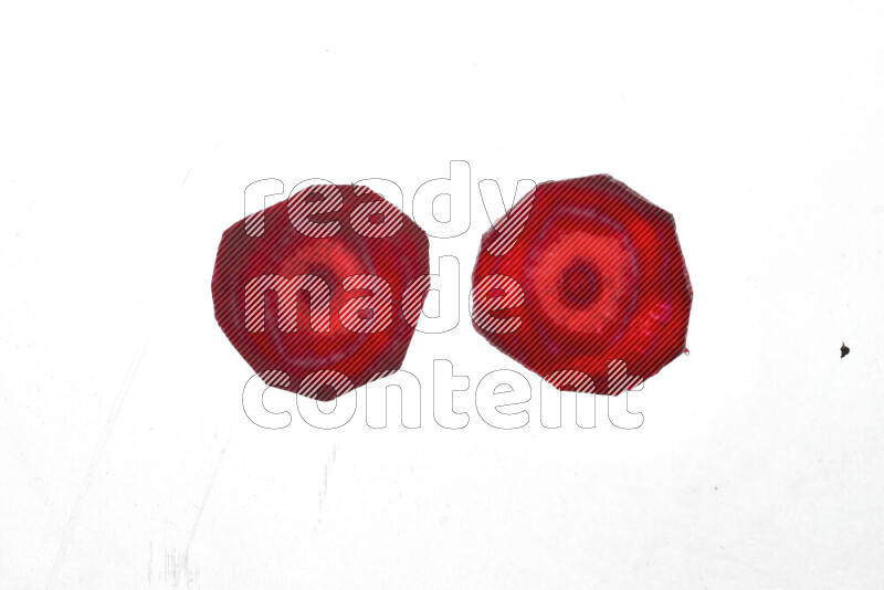 Beet slices on illuminated white background