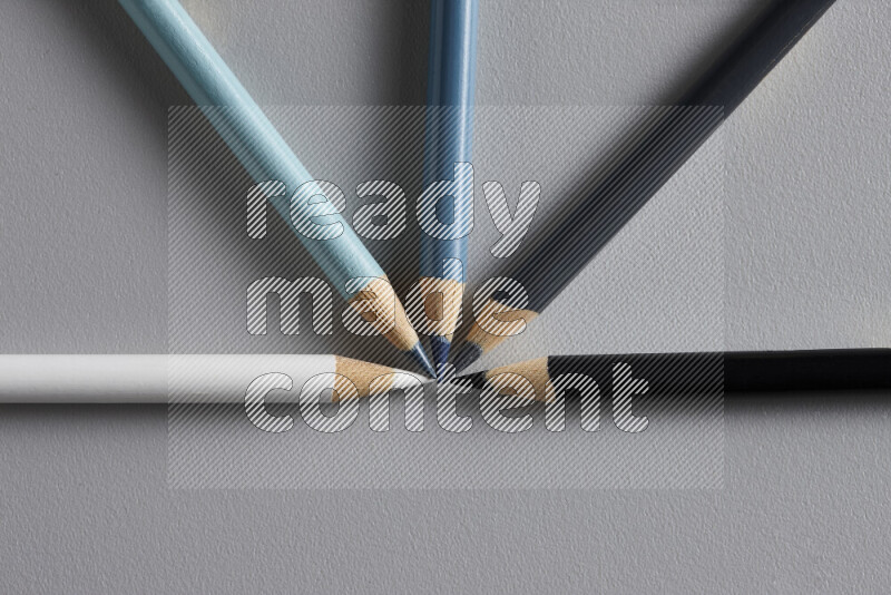 An arrangement of colored pencils in different colors on grey background