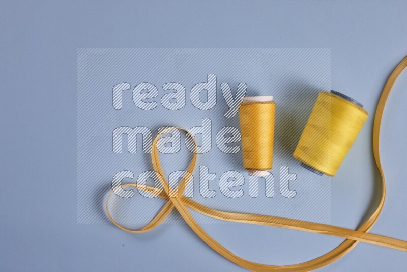 A yellow collection of sewing and tailoring tools arranged on a blue background