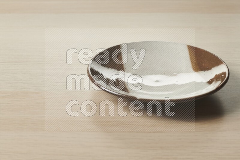 A multicolored pottery plate on light wooden background