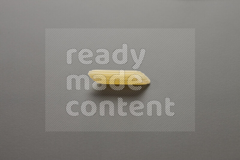 Mini penne pasta on grey background