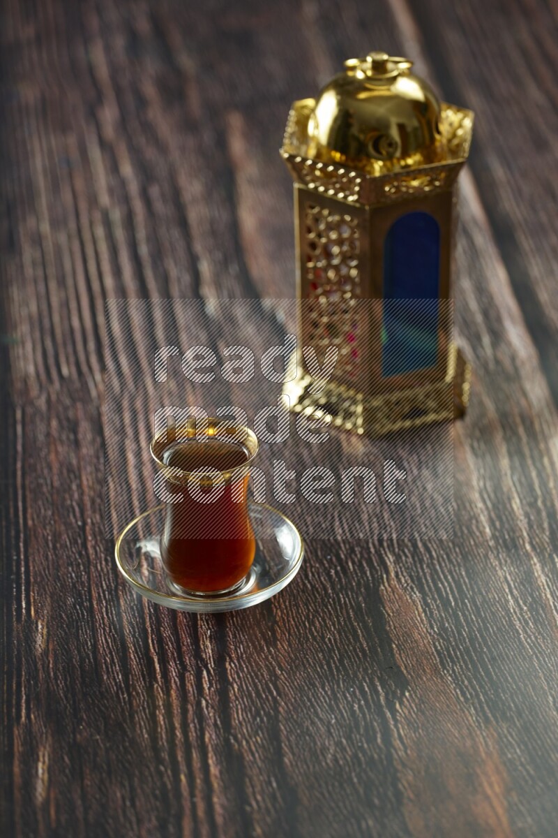 A golden lantern with different drinks, dates, nuts, prayer beads and quran on brown wooden background