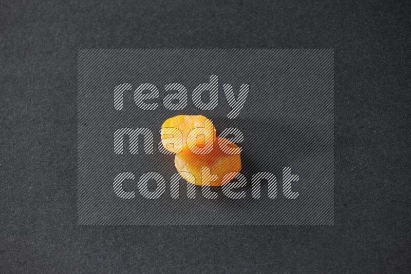 Two dried apricots on a black background in different angles