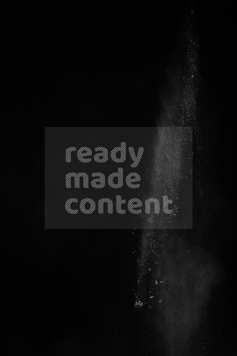 A side view of white powder explosion on black background