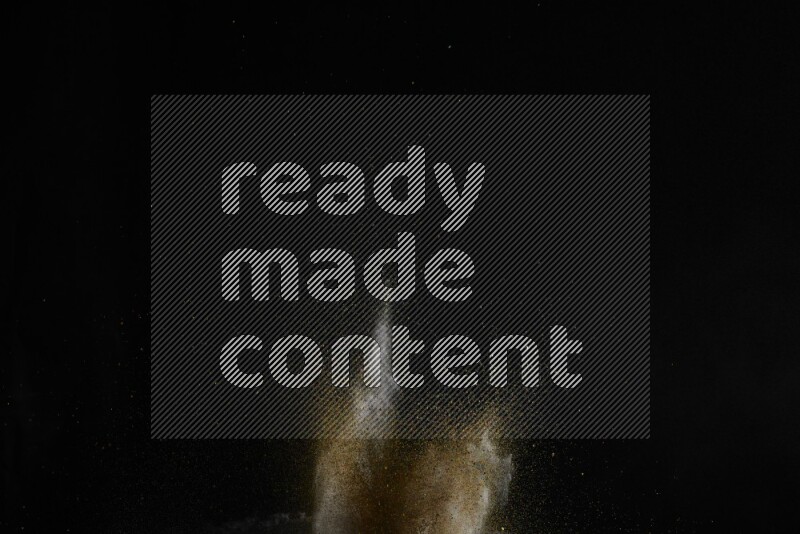 A side view of brown powder explosion on black background