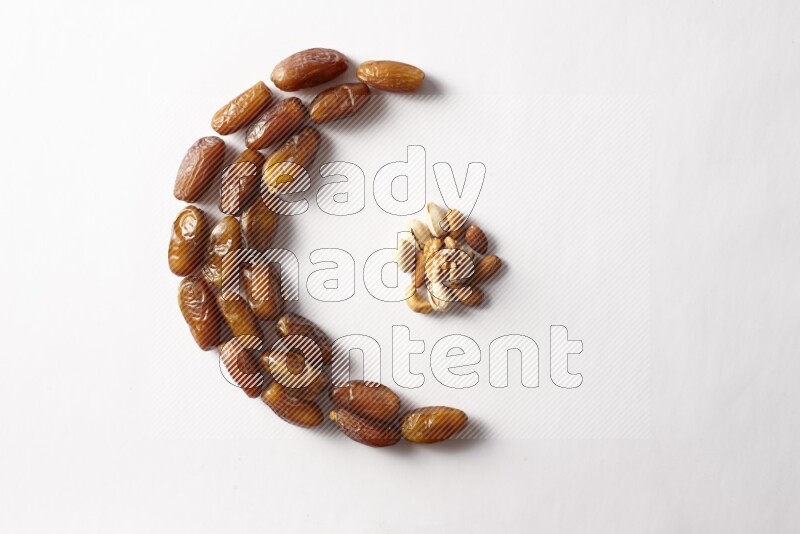Dates in a crescent shape with nuts on white background