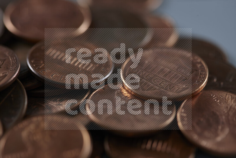 A close-up of scattered United States one cent coins on grey background