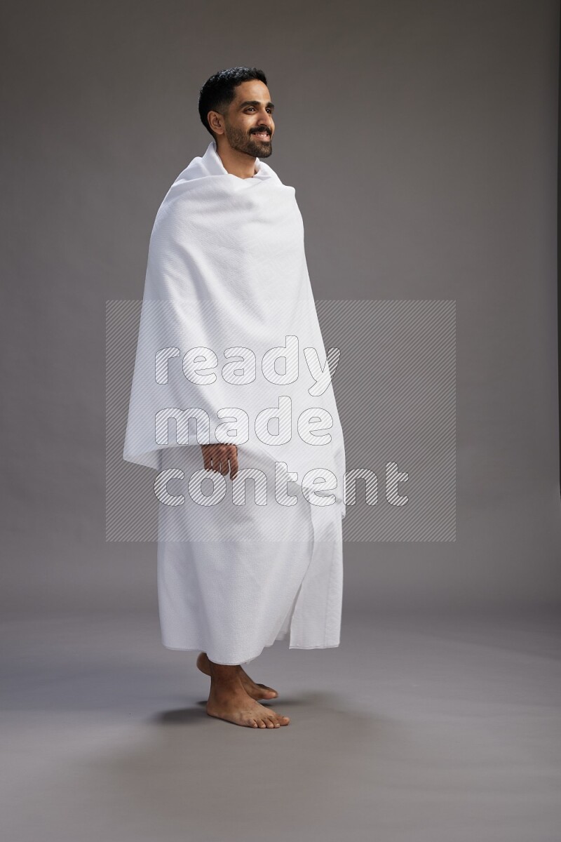 A man wearing Ehram Standing Interacting with the camera on gray background