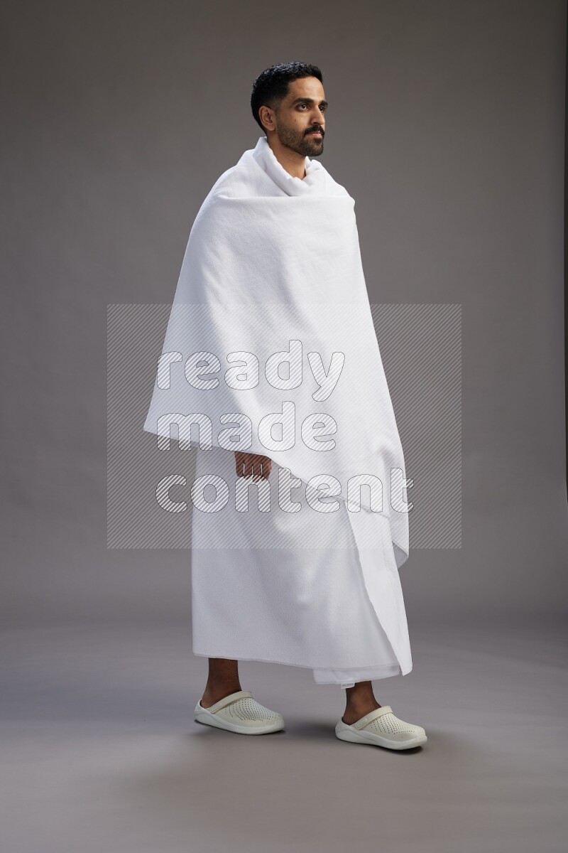 A man wearing Ehram Standing Interacting with the camera on gray background