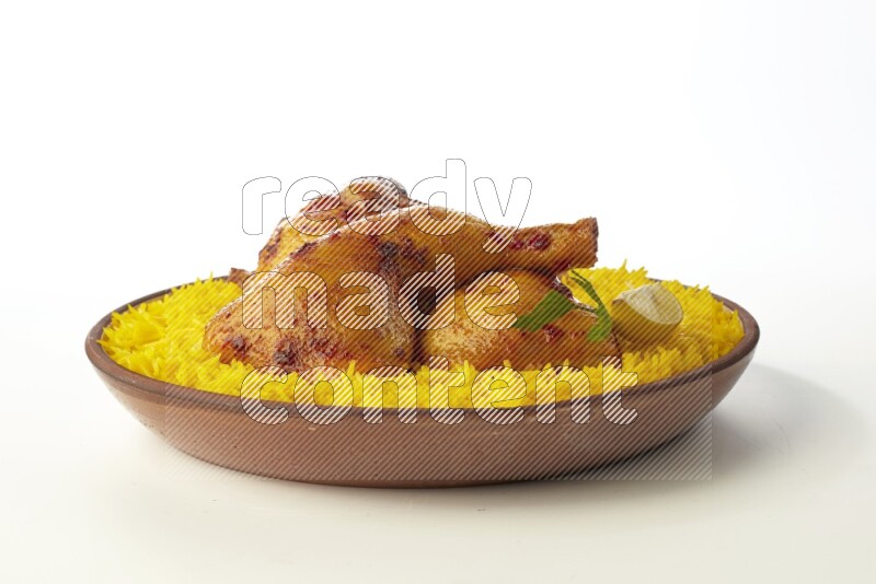 yellow basmati Rice with kabsa chicken pieces on a pottery plate direct on white background