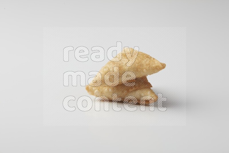 Two fried sambosas on a white background