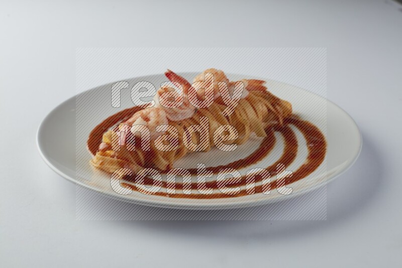 Fettuccini red sauce pasta with shrimp in a white plate on a white background