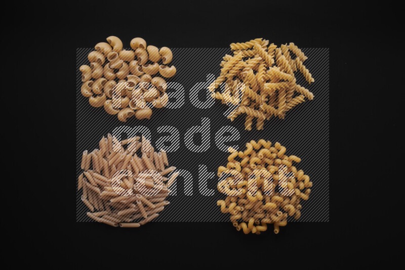 Different pasta types in bunches on black background